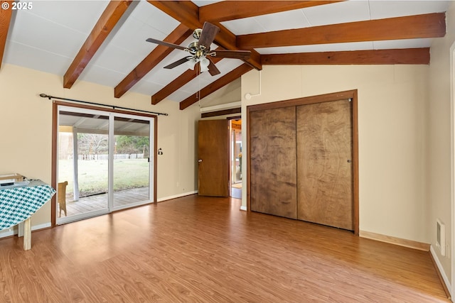 interior space featuring lofted ceiling with beams, ceiling fan, light wood-type flooring, and access to outside