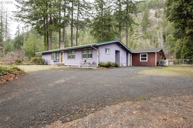 49855 Mckenzie Hwy, Vida, OR 97488 - ranch-style home featuring asphalt driveway and a chimney