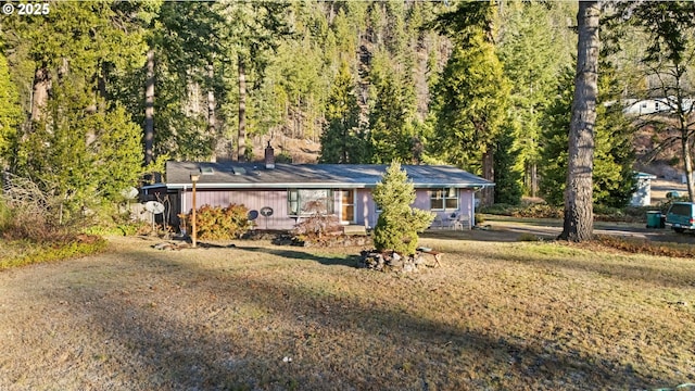 49855 Mckenzie Hwy, Vida, OR 97488 - view of front facade with a chimney, a view of trees, and a front yard