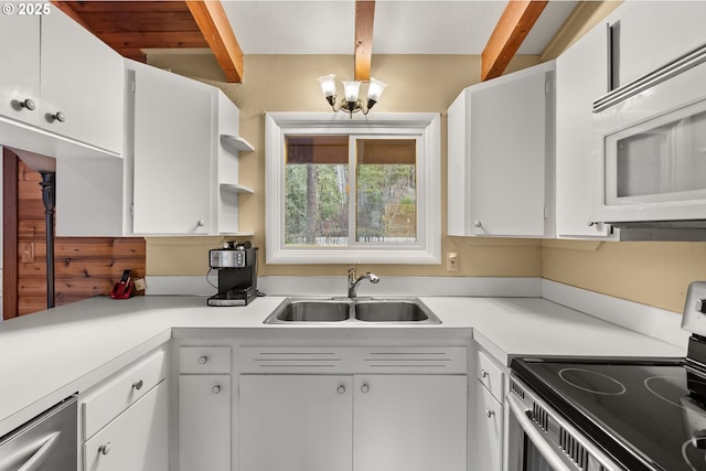 kitchen featuring stainless steel appliances, white cabinetry, sink, and pendant lighting