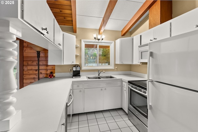 kitchen with beamed ceiling, white cabinetry, sink, and white appliances