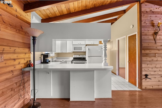 kitchen featuring wood walls, white cabinetry, sink, kitchen peninsula, and white appliances