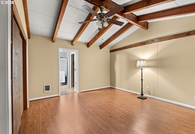 spare room with ceiling fan, vaulted ceiling with beams, and light wood-type flooring