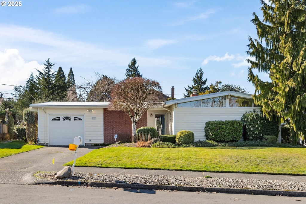 view of front of house with aphalt driveway, a front lawn, and a garage