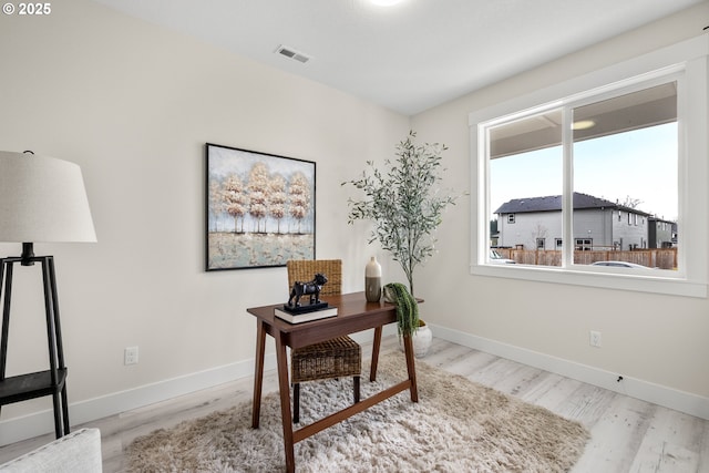 office featuring wood finished floors, visible vents, and baseboards