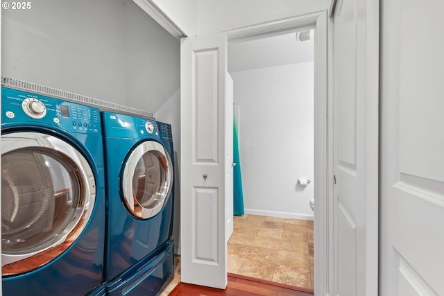laundry room featuring laundry area, baseboards, and separate washer and dryer