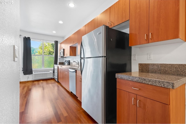 kitchen featuring wood finished floors, recessed lighting, tile countertops, a sink, and stainless steel appliances