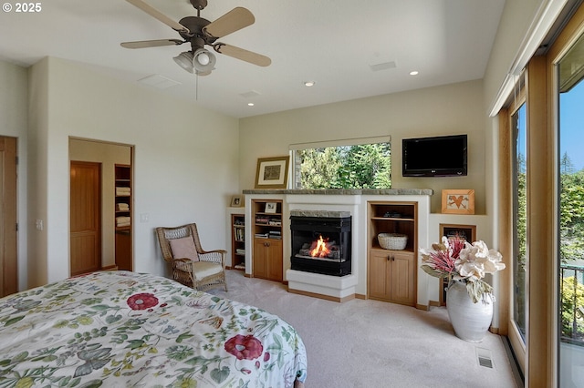 bedroom with ceiling fan, visible vents, a high end fireplace, light colored carpet, and recessed lighting