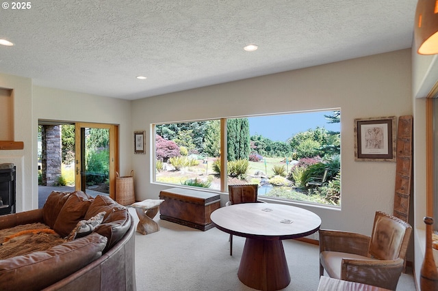 carpeted living area featuring a glass covered fireplace, recessed lighting, and a textured ceiling