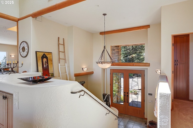 foyer entrance featuring a towering ceiling, visible vents, french doors, and a wealth of natural light