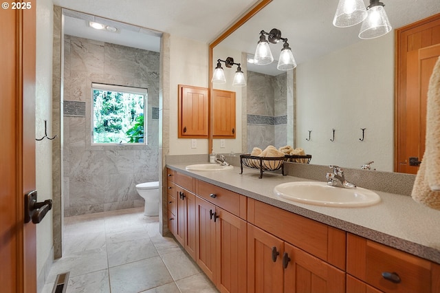 bathroom featuring double vanity, toilet, visible vents, and a sink