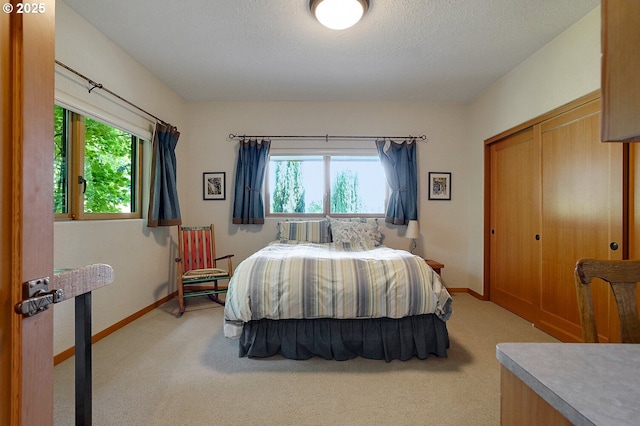 bedroom with baseboards, multiple windows, and light colored carpet