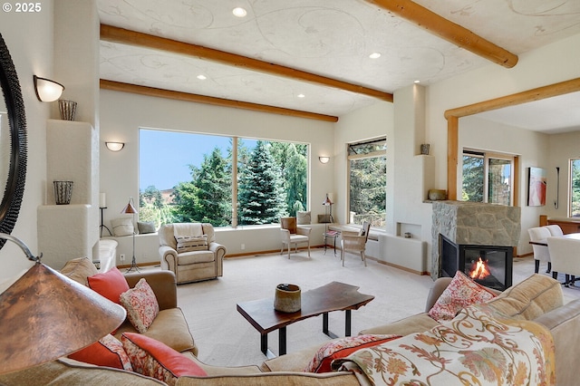 living area with carpet flooring, beam ceiling, a glass covered fireplace, recessed lighting, and baseboards