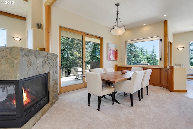 dining space featuring a healthy amount of sunlight, a multi sided fireplace, recessed lighting, and light colored carpet