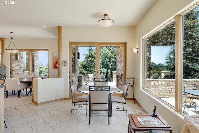 dining area with a healthy amount of sunlight, light tile patterned floors, and baseboards