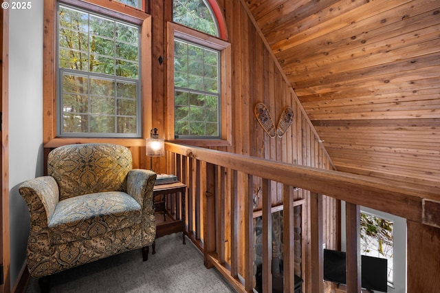 sitting room featuring lofted ceiling, wood ceiling, wooden walls, and carpet floors