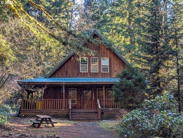 rustic home with covered porch and metal roof