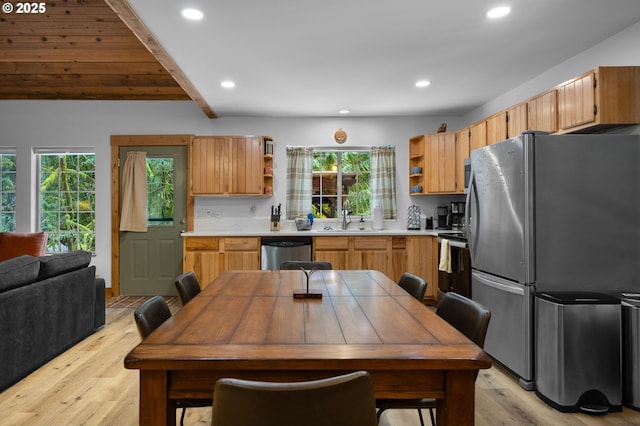 kitchen with open shelves, appliances with stainless steel finishes, a sink, and a healthy amount of sunlight