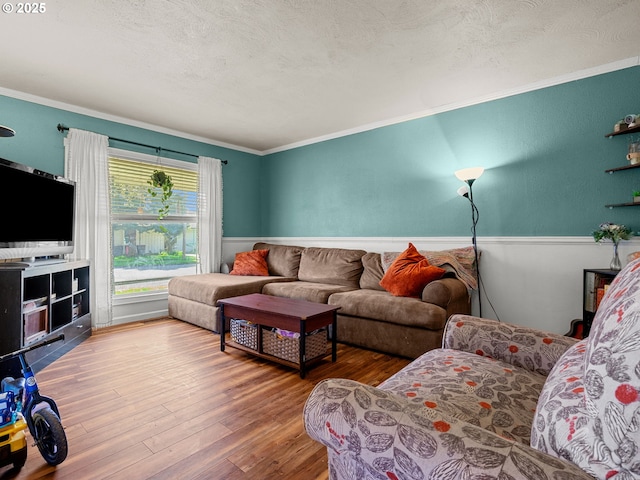 living room with ornamental molding, wood finished floors, and a textured ceiling