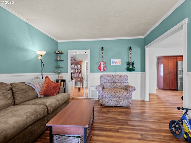 living room featuring a wainscoted wall, wood finished floors, and ornamental molding