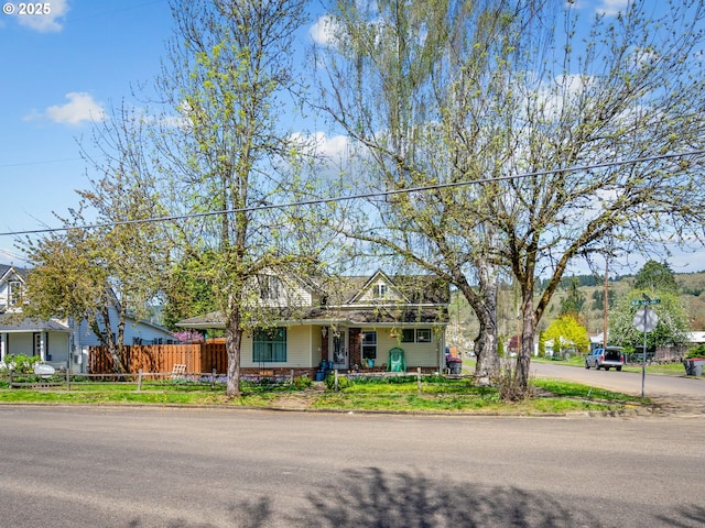 view of front of home with fence and a porch