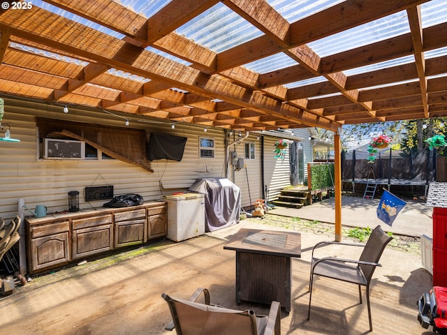view of patio / terrace featuring an outdoor kitchen, a pergola, a grill, and a trampoline