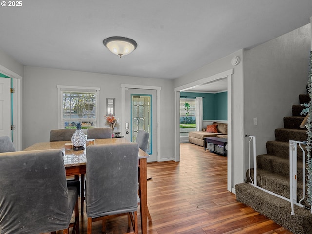 dining space featuring stairs, wood finished floors, and baseboards