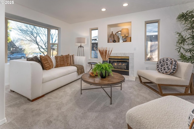 living room featuring carpet floors, a wealth of natural light, a premium fireplace, and recessed lighting