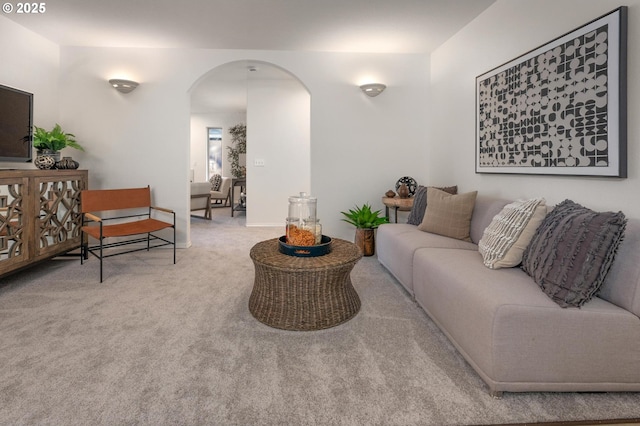 carpeted living area with arched walkways