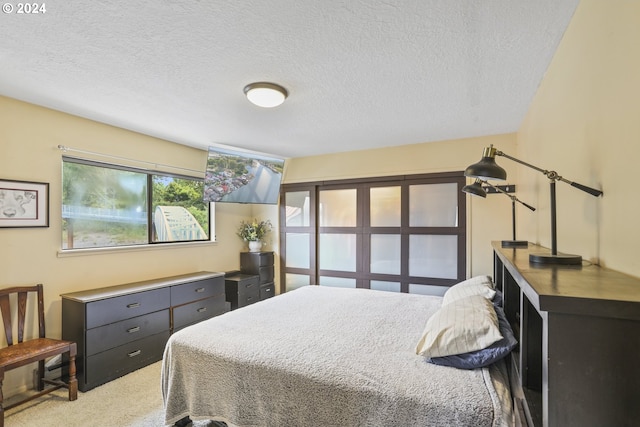 bedroom featuring a textured ceiling and light carpet