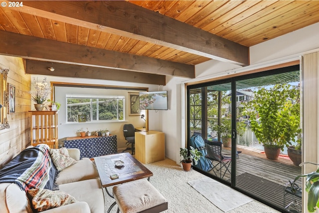 living room with beam ceiling, wood ceiling, and light colored carpet