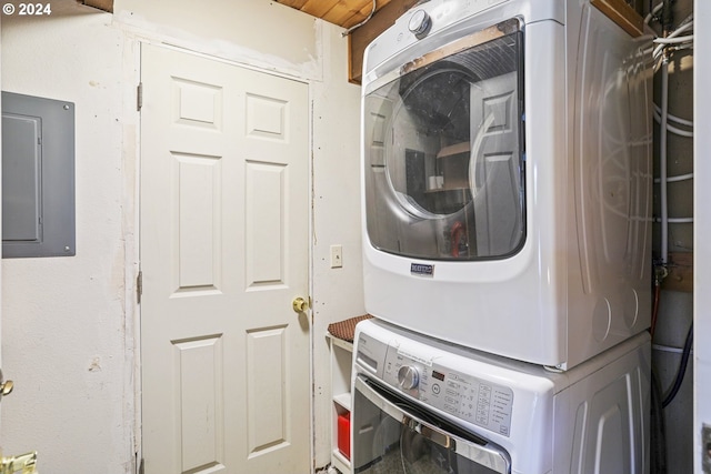 laundry room featuring electric panel and stacked washing maching and dryer