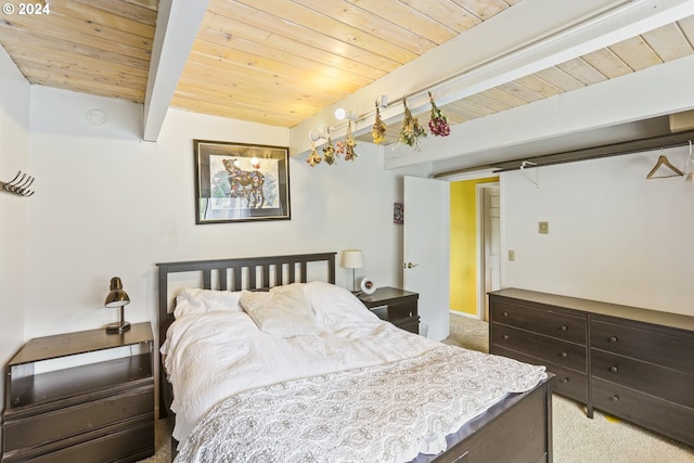 bedroom with beamed ceiling, carpet floors, and wood ceiling