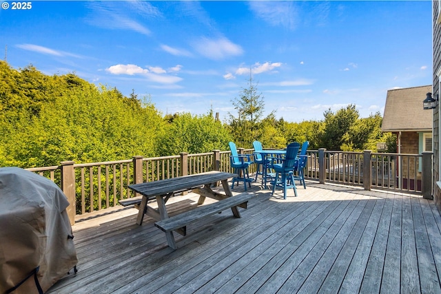 deck featuring outdoor dining area and grilling area