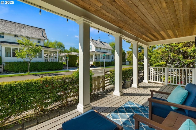 wooden terrace with covered porch and a residential view