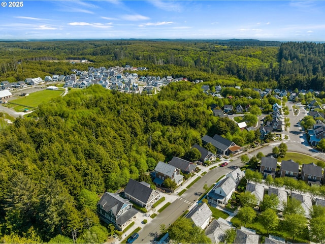 aerial overview of property's location with a forest and nearby suburban area