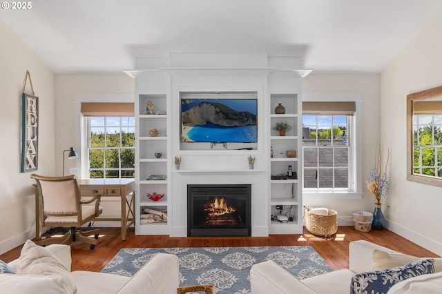 living room featuring a large fireplace, wood finished floors, and baseboards