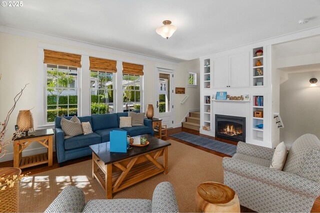 living area with built in features and a fireplace with flush hearth