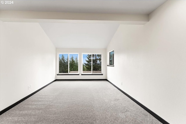 carpeted empty room featuring lofted ceiling with beams