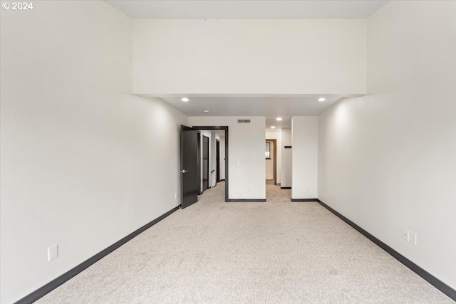 unfurnished room featuring light carpet