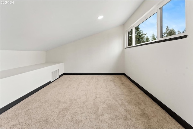 bonus room with carpet floors and vaulted ceiling