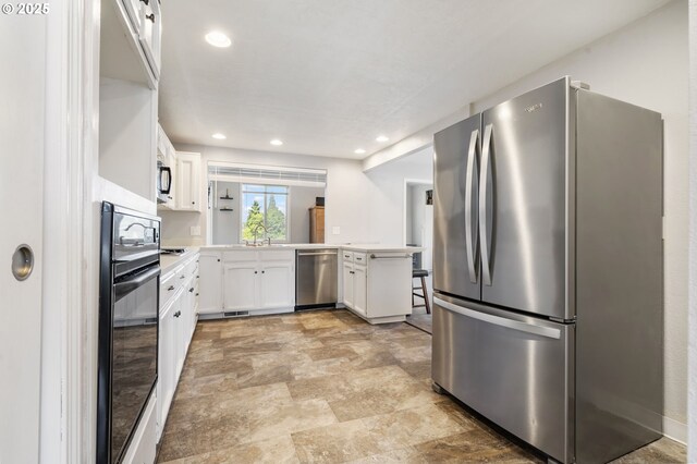 461 NE 16th Ave, Hillsboro, OR 97124 - kitchen featuring stainless steel appliances, a peninsula, light countertops, white cabinets, and recessed lighting
