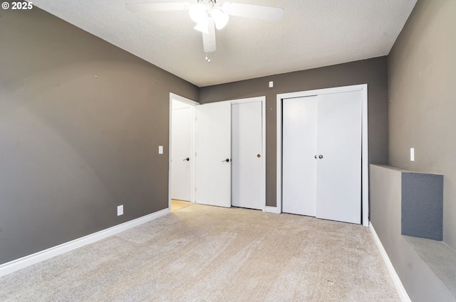 461 NE 16th Ave, Hillsboro, OR 97124 - unfurnished bedroom with two closets, carpet flooring, a textured ceiling, baseboards, and a ceiling fan