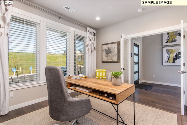 office with dark wood-style floors, visible vents, and baseboards