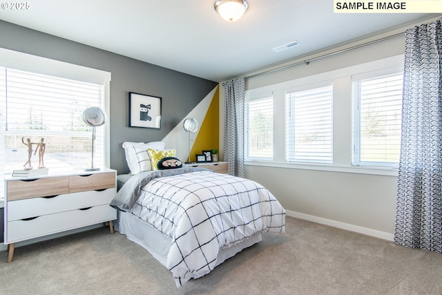 bedroom with visible vents, baseboards, and light colored carpet