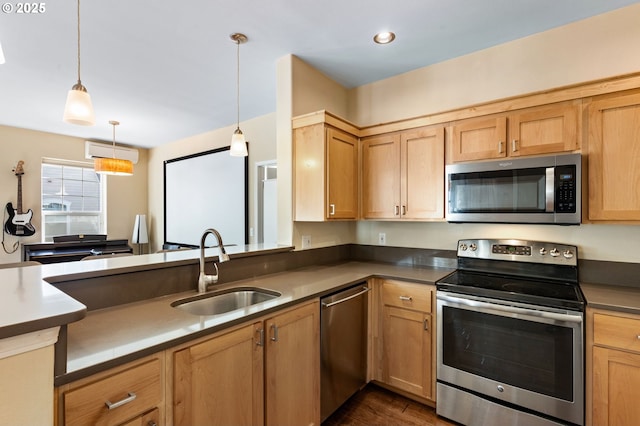 kitchen with a sink, dark wood finished floors, recessed lighting, appliances with stainless steel finishes, and hanging light fixtures