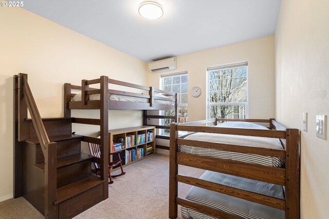 carpeted bedroom featuring baseboards and a wall mounted air conditioner
