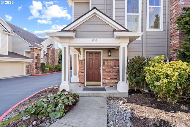property entrance featuring covered porch and brick siding