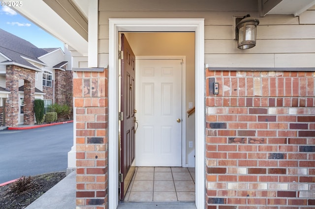 view of exterior entry featuring brick siding