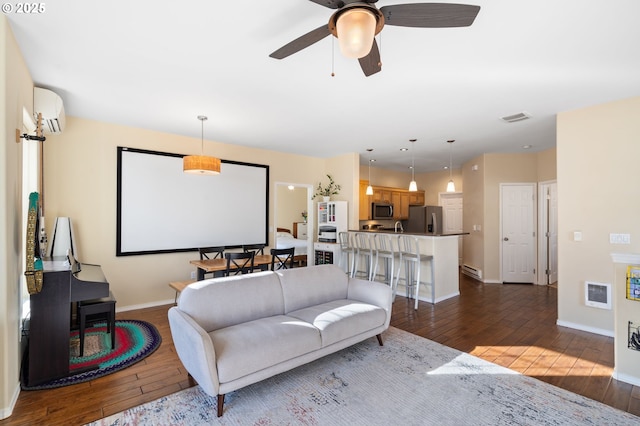 living area featuring visible vents, wood-type flooring, baseboards, and a wall unit AC